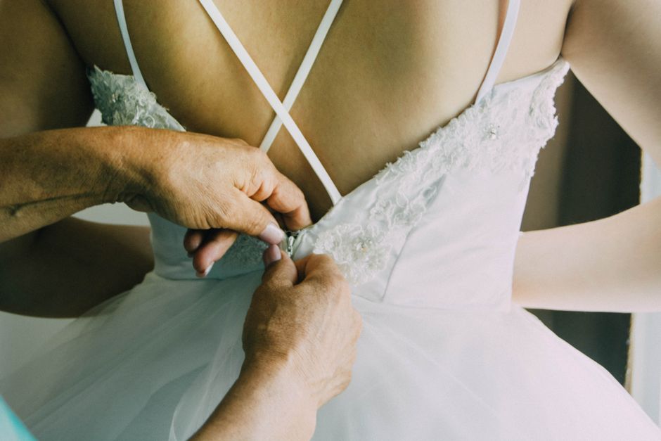 Bride getting ready with the help of a day of coordinator